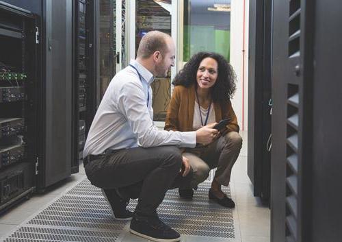 2 people working in computer server room.